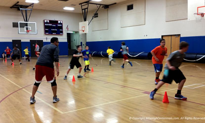 Coach Armando guides a group of boys working on closing out during a Centennials basketball clinic in South Denver, Colorado